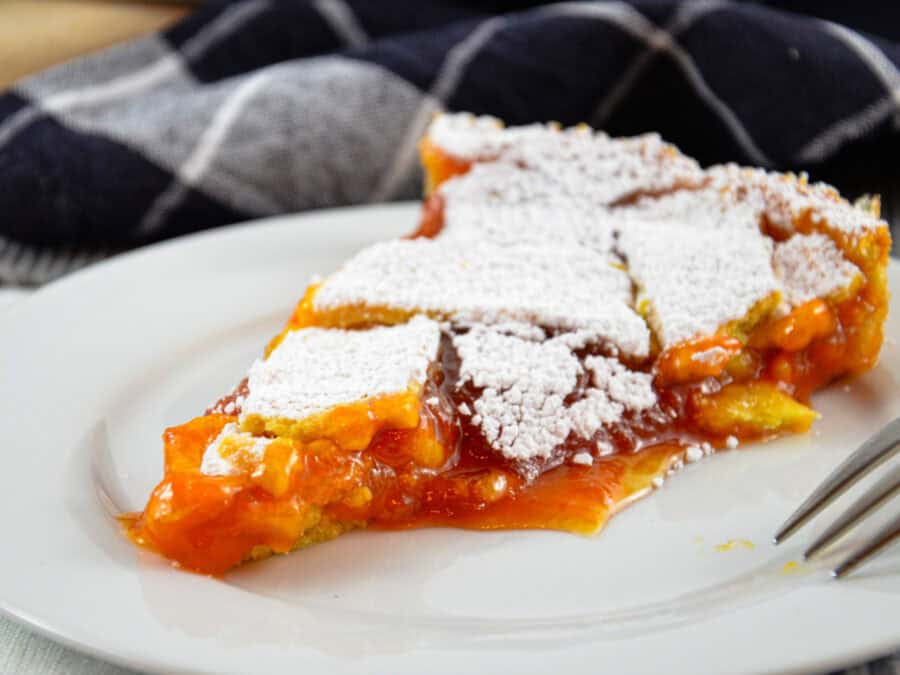 Italienische Crostata mit Marillen: 1 Stück auf einem Teller, von schräg vorne
