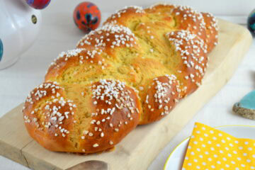 Osterstriezel aus Hefeteig auf einem hellen Schneidbrett, von schräg vorne