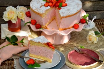 Erdbeer-Käsesahne-Torte, 1 Stück auf Teller, hinten die Torte
