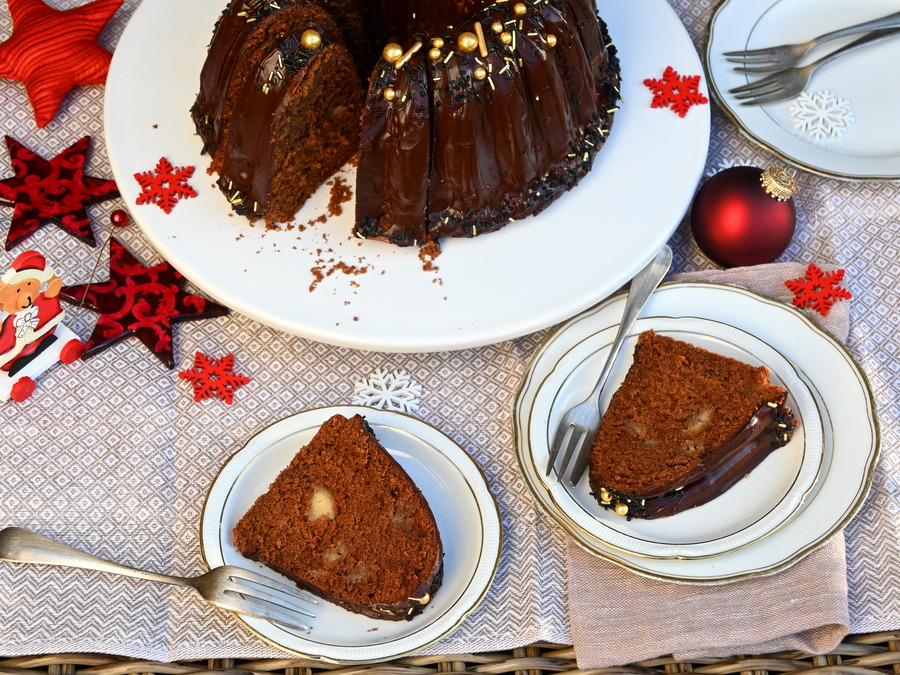 Weihnachtlicher Sacher-Gugelhupf-mit-Marzipan, zwei Stück auf Tellern, hinten der Gugelhupf