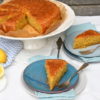 Zitronen-Polenta-Kuchen: 2 Stück vorne auf Tellern, hinten der Kuchen