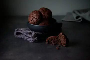Chocolate Cookies mit Tahini, vegan: 1 Cookie ist in 2 Hälften geteilt; Ansicht von schräg vorne