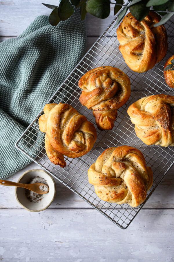 Kardamomschnecken aus Hefeteig auf einem Backgitter, von oben