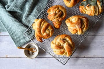 Kardamomschnecken aus Hefeteig auf einem Backgitter, von oben
