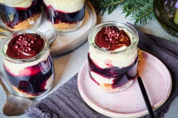 Dessert mit Mascarponecreme und Vanille-Orangen-Kirschen: Vorne 1 Glas auf einem Teller, im Hintergrund ein Tannenzweig