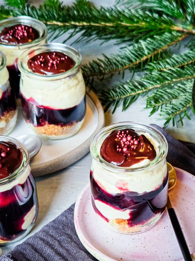 Dessert mit Mascarponecreme und Vanille-Orangen-Kirschen: Vorne 1 Glas auf einem Teller, im Hintergrund ein Tannenzweig