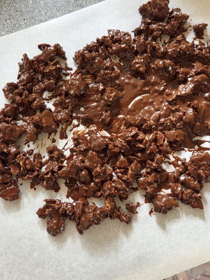 Schoko-Mandel-Crunch auf einem Backpapier, ausgebreitet zum Auskühlen