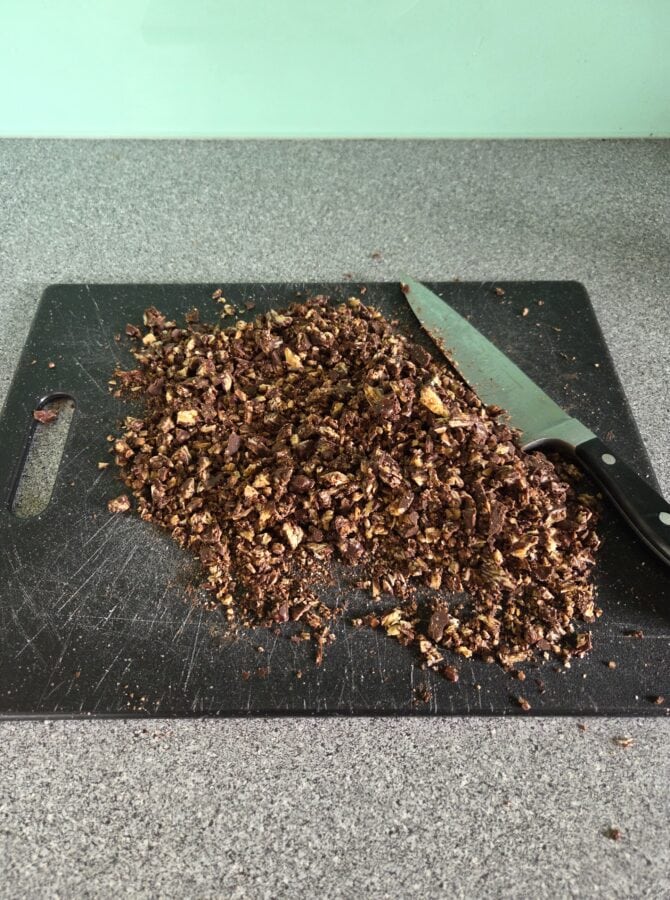 Gehackter Schoko-Mandel-Crunch auf einem Schneidbrett