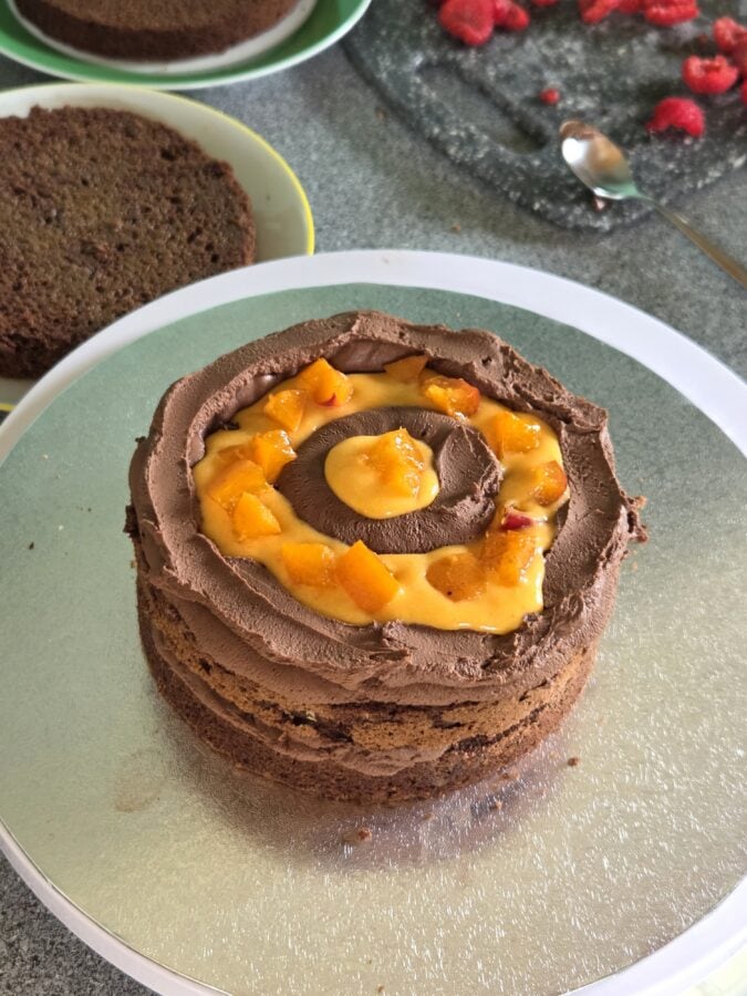 Schokoladentorte wird zusammengesetzt, mit einer Schicht Schokoladenganache und Marillencurd